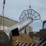 crane lifting steel chimney with platform